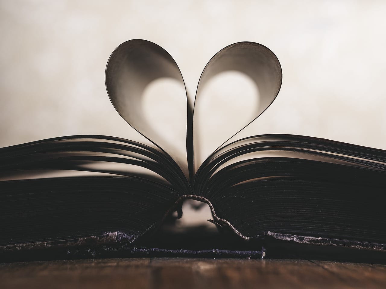 Stock image shows a book laid open. Two central pages have been folded in together forming the shape of a heart in the middle of the image